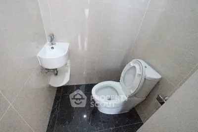 Compact modern bathroom with sleek fixtures and tiled flooring