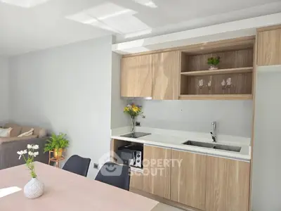 Modern kitchen with sleek wooden cabinets and cozy dining area