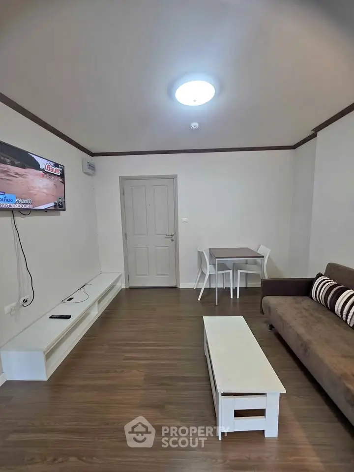 Modern living room with sleek furniture and mounted TV, perfect for relaxation.