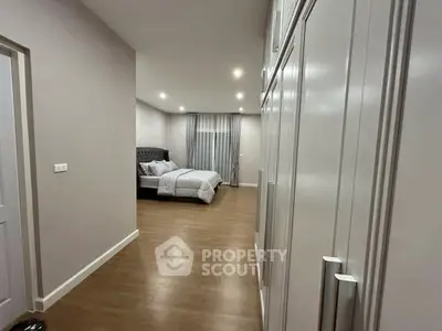 Spacious bedroom with elegant wooden flooring and ample closet space