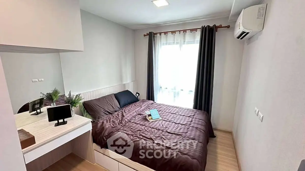Cozy bedroom with modern decor, featuring a comfortable bed, air conditioning, and natural light from large window.
