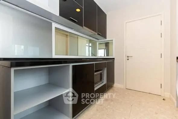 Modern kitchen with sleek black cabinets and built-in microwave