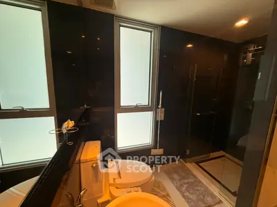 Luxurious modern bathroom with sleek black tiles and frosted windows