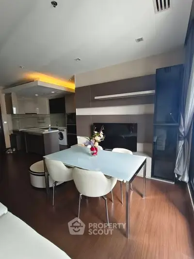 Modern open-layout living room with dining area and stylish kitchen in a contemporary apartment.