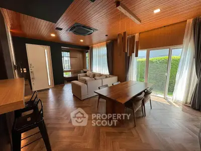 Luxurious modern living room with wooden accents and large windows opening to a lush garden view.