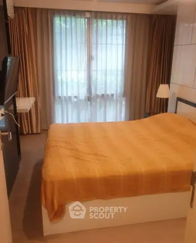 Cozy bedroom with large window and modern furnishings in a stylish apartment.