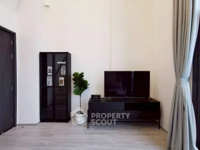 Modern living room with sleek black furniture and a potted plant, perfect for stylish urban living.