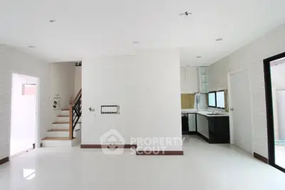 Modern open-plan interior with sleek kitchen and staircase, perfect for contemporary living.