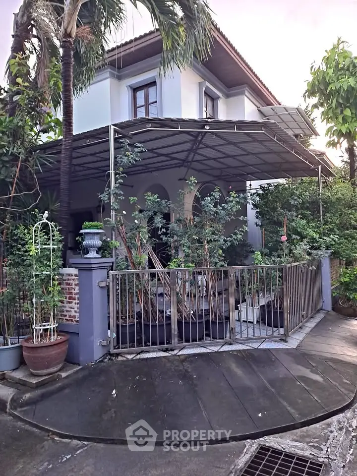 Charming two-story house with lush garden and covered patio in a serene neighborhood.