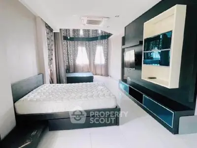 Spacious modern bedroom with sleek black furniture and large windows