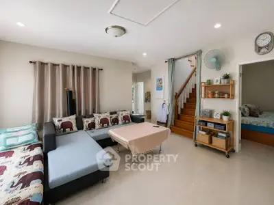 Spacious living room with modern decor and cozy seating area, perfect for family gatherings.