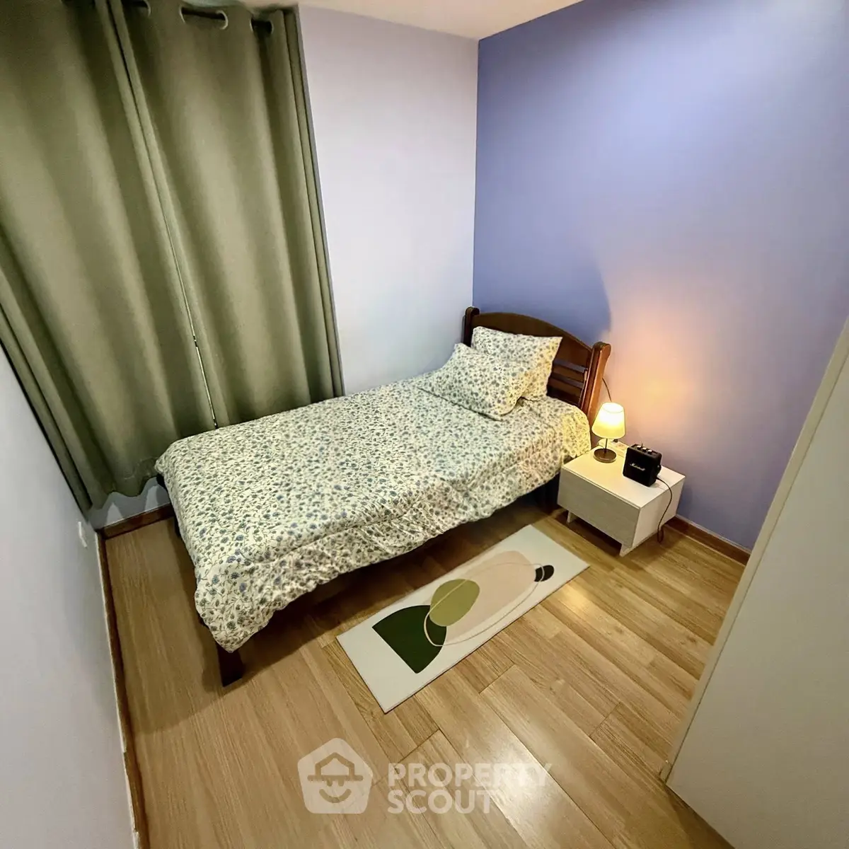 Cozy bedroom with single bed, wooden flooring, and soft lighting, perfect for relaxation.
