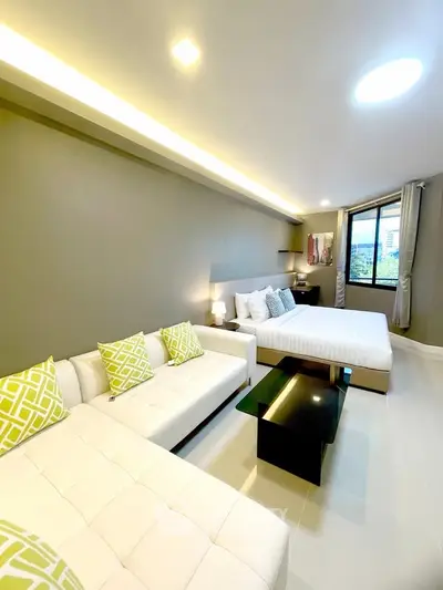 Modern bedroom with stylish decor and large windows offering natural light.