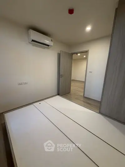 Modern bedroom with air conditioning and wooden flooring