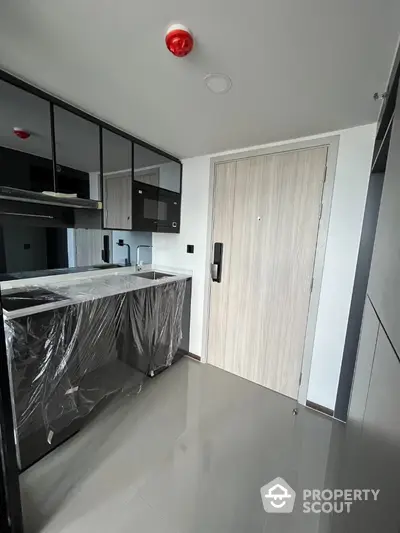 Modern kitchen with sleek cabinetry and glossy flooring in a stylish apartment.