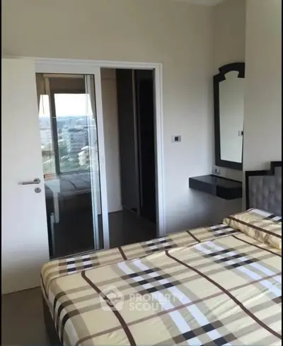 Modern bedroom with stylish decor and city view, featuring a comfortable bed and sleek furnishings.