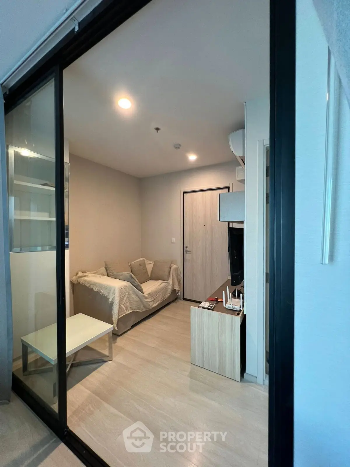 Modern living room with sliding glass doors and cozy sofa in stylish apartment.