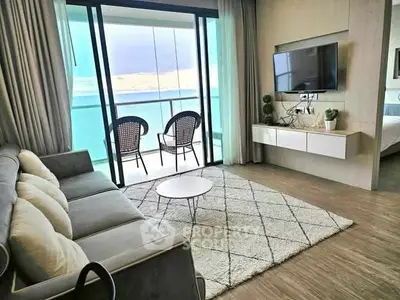 Modern living room with ocean view balcony, stylish decor, and cozy seating area.