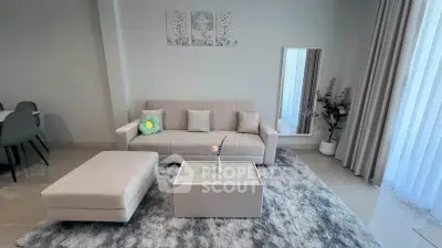 Modern living room with stylish decor and plush rug, featuring a comfortable sofa and elegant coffee table.