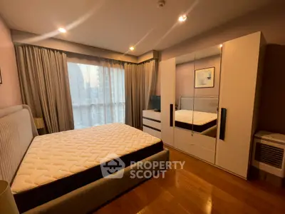 Spacious bedroom with city view, modern furniture, and ample natural light.