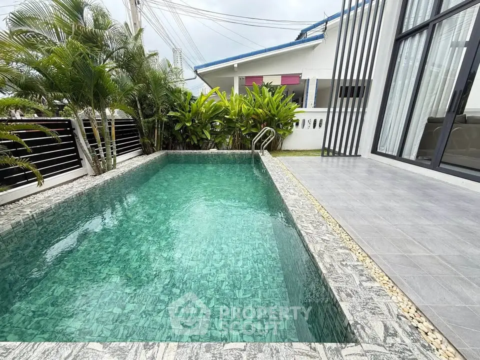 Stunning private pool with lush greenery and modern patio in a luxurious home setting.