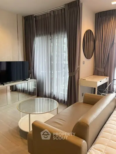 Modern living room with stylish furniture and large windows offering natural light.