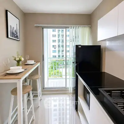 Modern kitchen with sleek black appliances and breakfast bar overlooking balcony view.