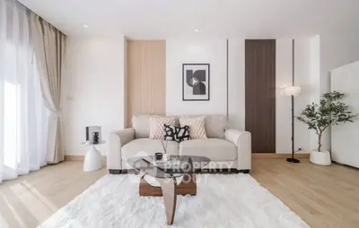 Modern living room with stylish decor and cozy ambiance, featuring a plush rug and elegant furniture.