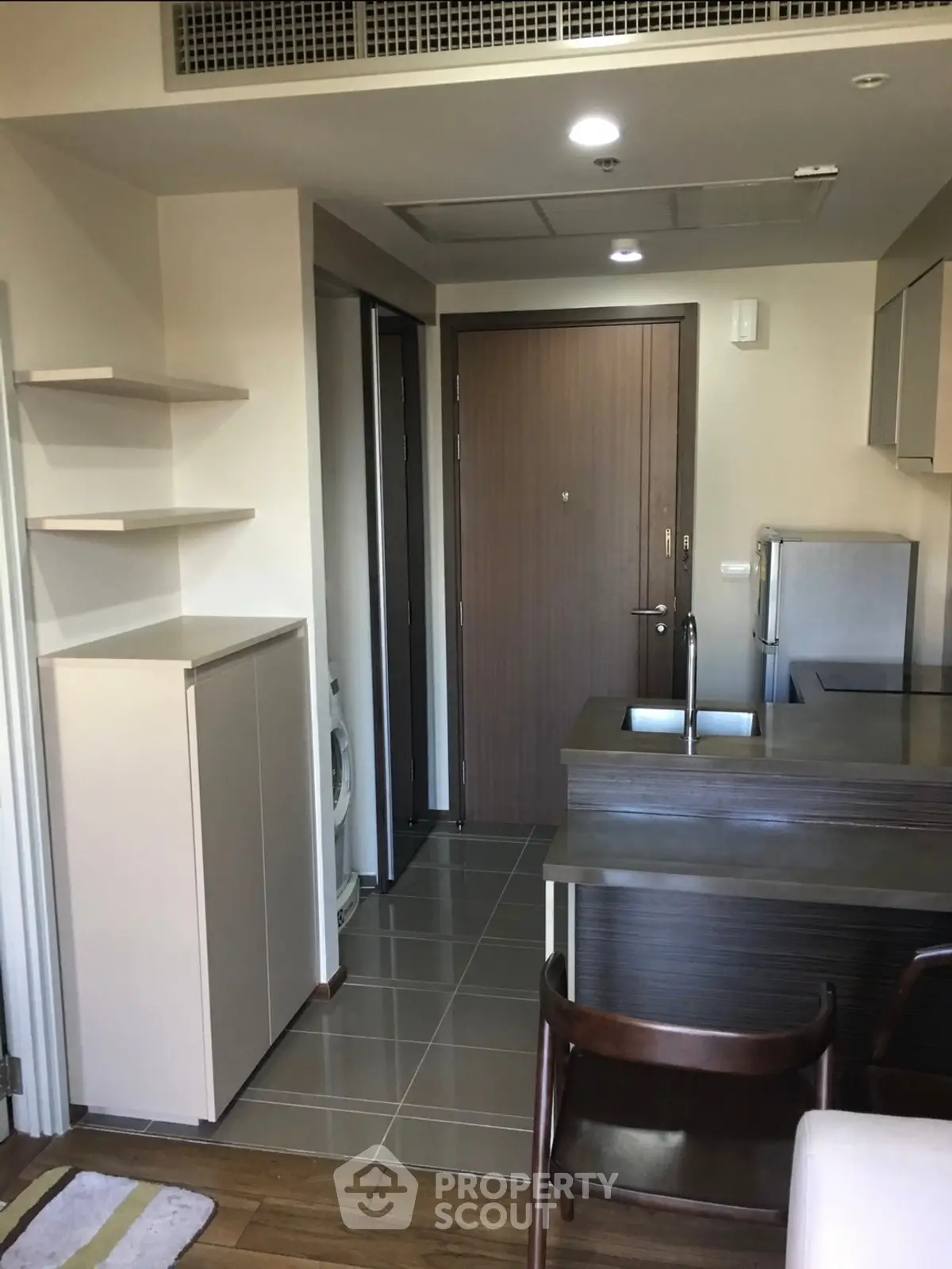 Modern apartment entrance with compact kitchen and washing machine