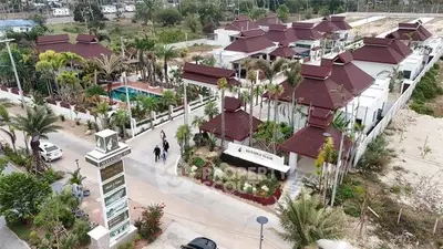 Aerial view of luxurious residential complex with pool and lush landscaping.