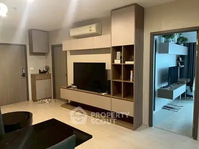 Modern living room with sleek TV unit and open doorway to another room