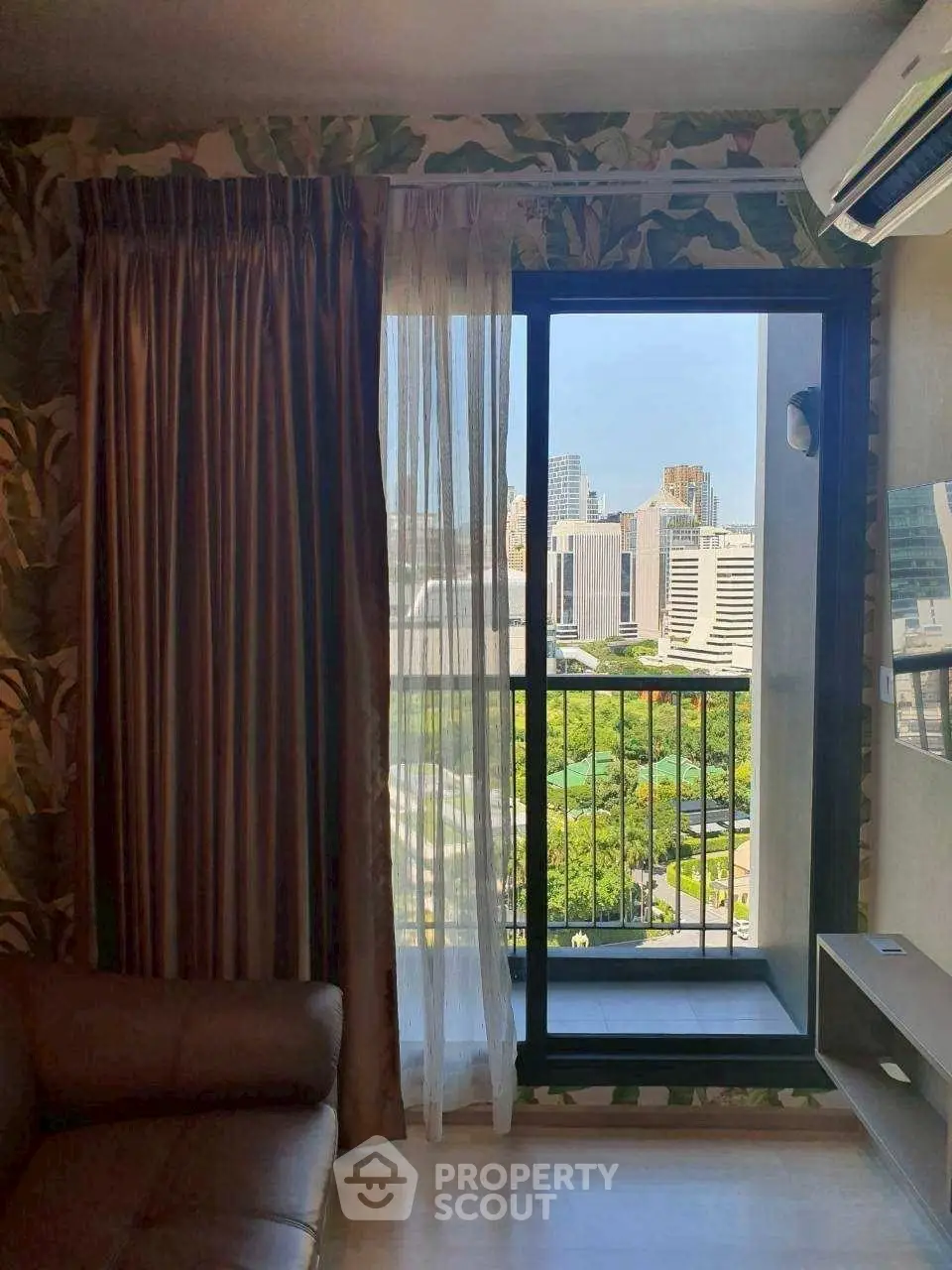 Stylish living room with city view and balcony access, perfect for urban living.