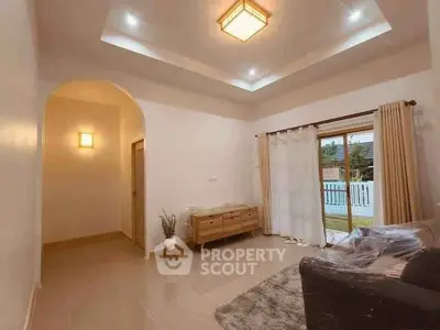 Spacious living room with modern lighting and large window opening to a balcony.