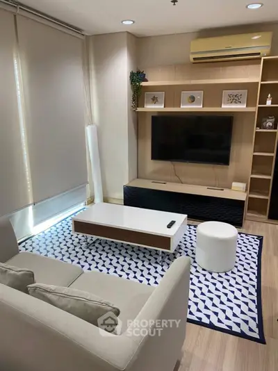 Modern living room with stylish decor, featuring a sleek TV setup and cozy seating area.