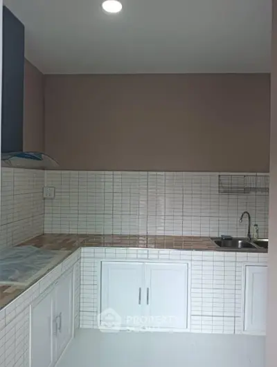 Modern kitchen with sleek white cabinets and tiled backsplash