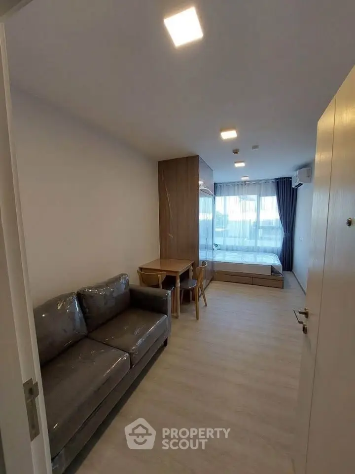 Modern living room with sleek furniture and large window for natural light.