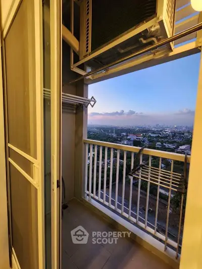 Stunning balcony view from high-rise apartment overlooking cityscape at sunset.