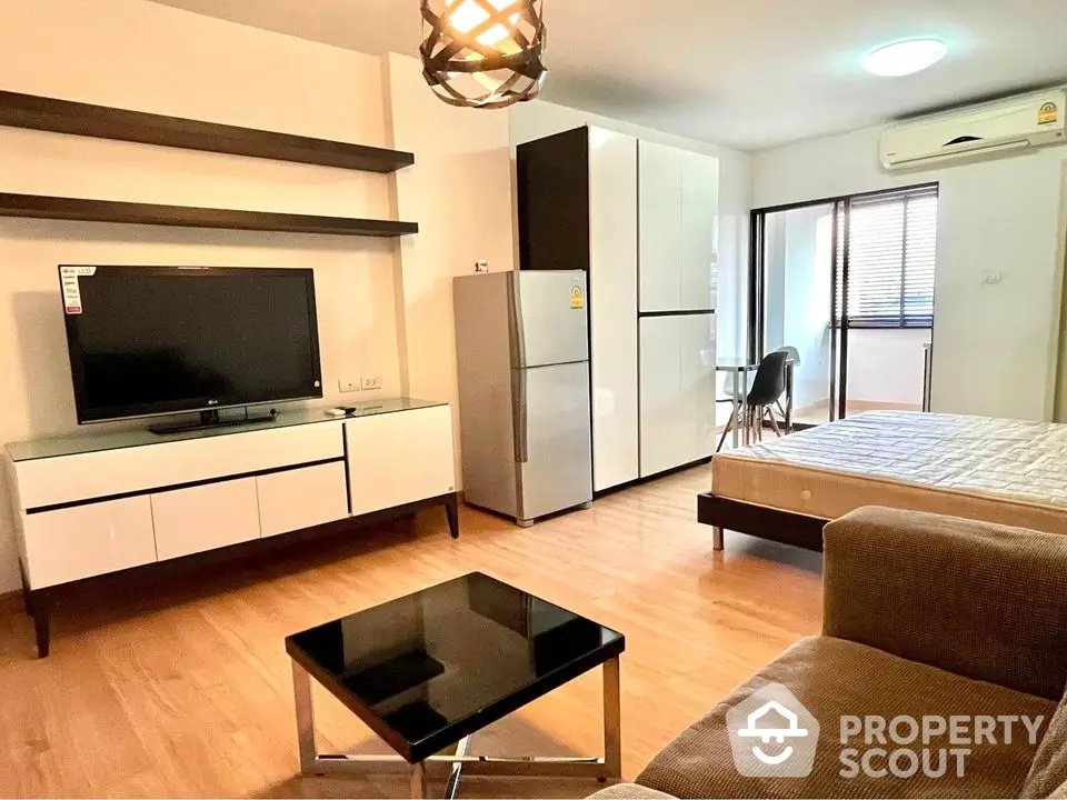 Modern studio apartment with open layout, featuring sleek furniture and natural light.