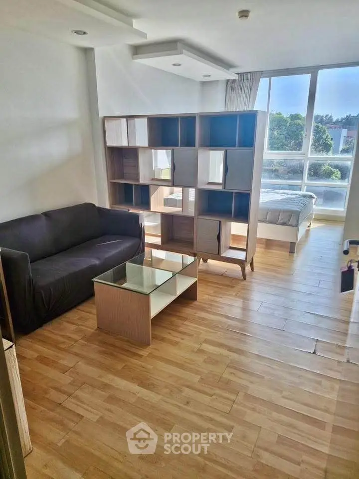 Modern studio apartment with wooden flooring and natural light