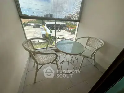 Cozy balcony with modern furniture and city view, perfect for relaxation.