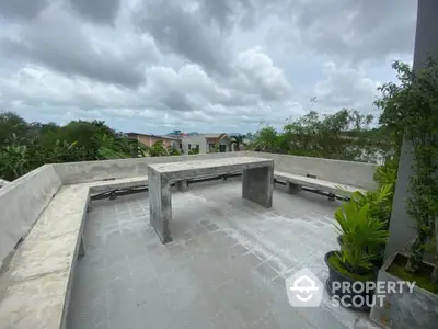 Spacious rooftop terrace with panoramic views and modern concrete seating area.