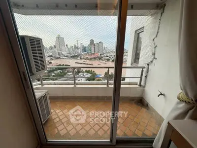 Stunning city view from a high-rise balcony with sliding glass doors and air conditioning units.