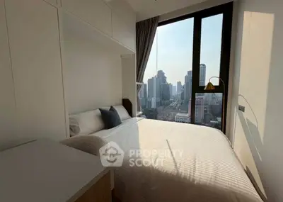 Cozy bedroom with city view, modern furnishings, and ample natural light.