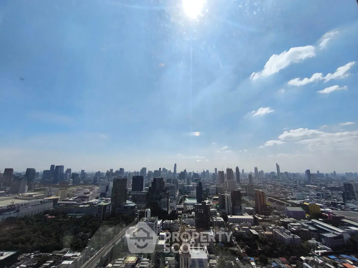 Stunning cityscape view from a high-rise building showcasing urban skyline under a bright blue sky.