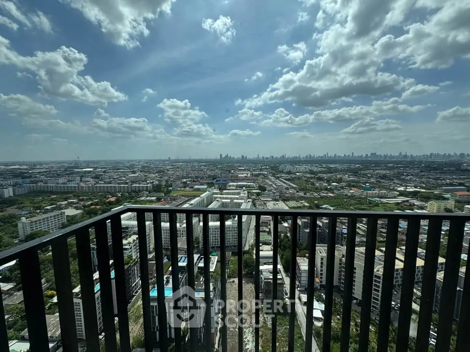 Stunning cityscape view from high-rise balcony with expansive skyline and blue sky.