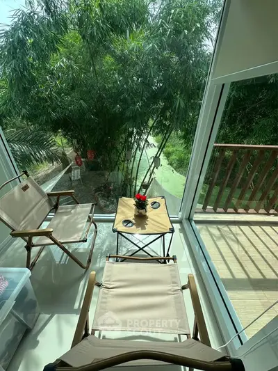 Charming balcony with lush garden view, perfect for relaxation and enjoying nature.