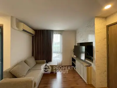 Modern living room with cozy sofa, large TV, and elegant decor, perfect for relaxation and entertainment.