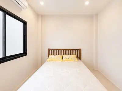 Cozy minimalist bedroom with natural light and modern air conditioning