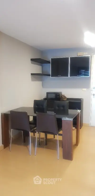 Modern dining area with sleek black furniture and open shelving