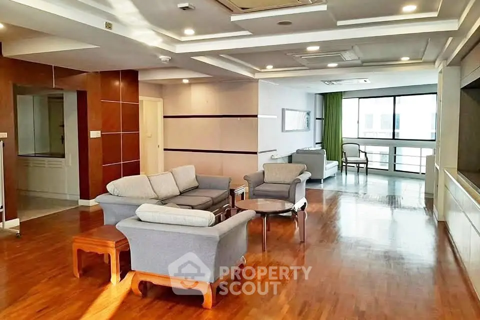 Spacious living room with elegant wooden flooring and modern furniture in a bright apartment.